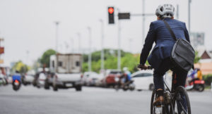 Ein Mann im Anzug fährt mit dem Fahrrad durch die Stadt.