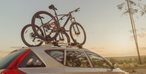 Fahrräder auf einem Autodach bei Sonnenuntergang.