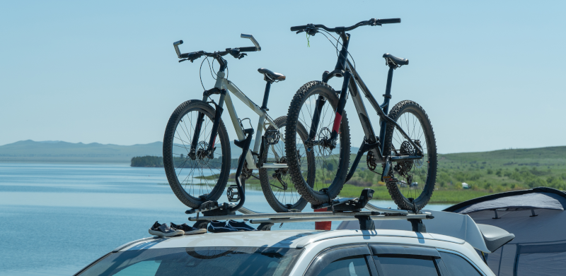 Zwei Fahrräder, die auf einem Autodach befestigt sind.