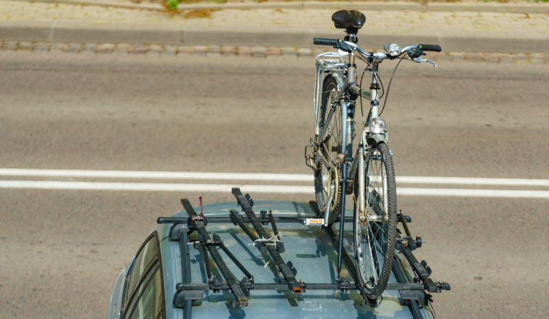 Absicht von oben auf ein Fahrrad, das auf einem Autodach befestigt ist.