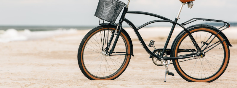 Ein Retro-Fahrrad, das auf einem Sandstrand abgestellt ist.