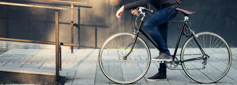 Nahaufnahme eines Mannes in Jeans auf einem Fahrrad in der Stadt