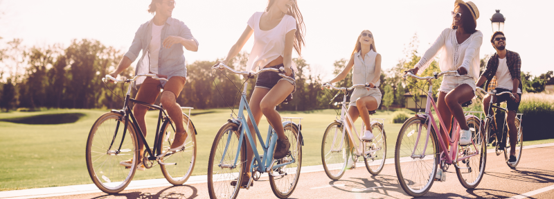 Eine Gruppe von jungen Menschen bei einer Radtour im Sommer.