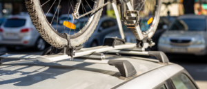 Teilansicht eines Fahrrads, das auf einem Autodach befestigt ist.