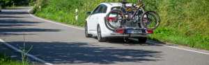 Ein weißer Kleinwagen transportiert zwei Fahrräder auf einem Heckträger.