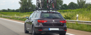 Ein Kleinwagen mit zwei Fahrrädern auf dem Autodach.