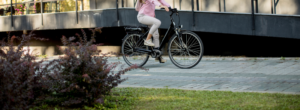 Eine Frau fährt in städtischer Umgebung mit einem E-Bike.
