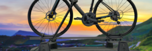 Ein Fahrrad auf einem Autodach, im Hintergrund Sonnenuntergang