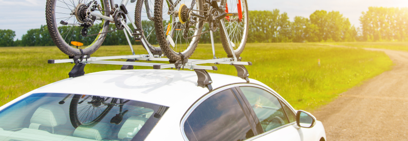 Teilansicht zweier Fahrräder auf einem weißen Autodach.