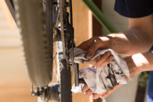 Mann putzt und repariert Kette seines Rades